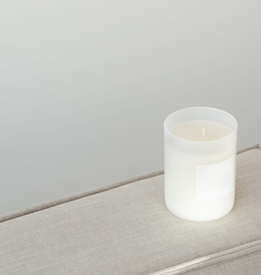 kaboompics_candle-in-white-glass-with-label-on-linen-couch-27078